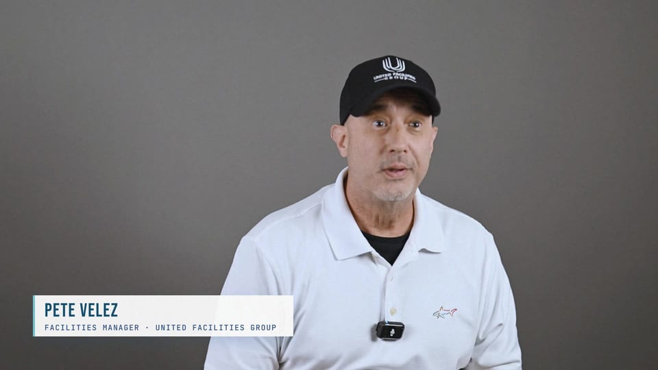 Pete Velez speaking in a black UFG cap and white polo, a frame from the film What's In It For You