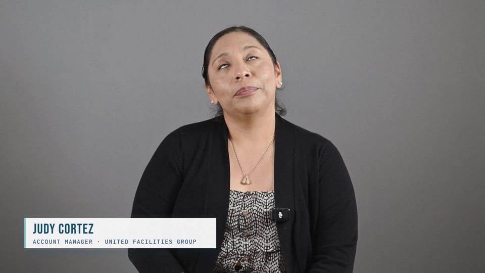 Judith Cortes in a black cardigan, looking up thoughtfully, a frame from the film Answer the Email