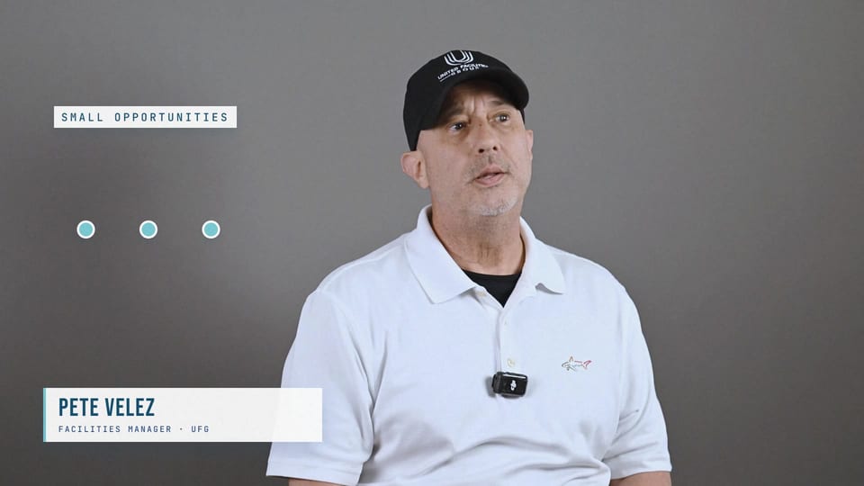 Pete Velez in a black UFG cap and white polo, looking up, a frame from the film The Little Things