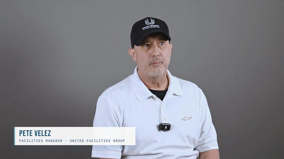 Pete Velez in a black UFG cap and white polo, looking aside, a frame from the film Coach, Culture, Cohesion